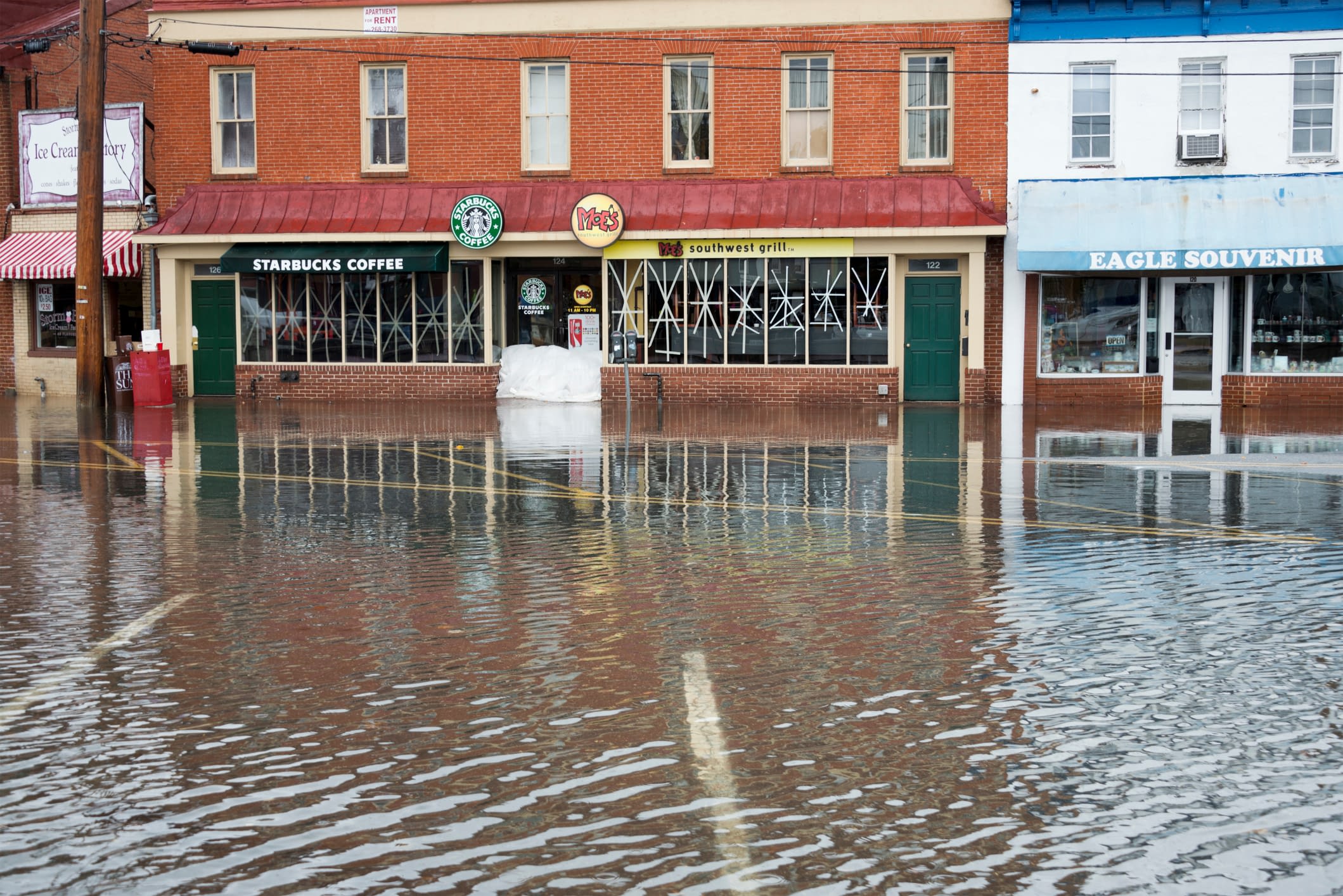 Flooded streets in front of business storefronts