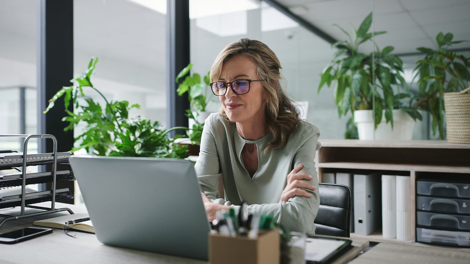 Older female business owner reading on laptop