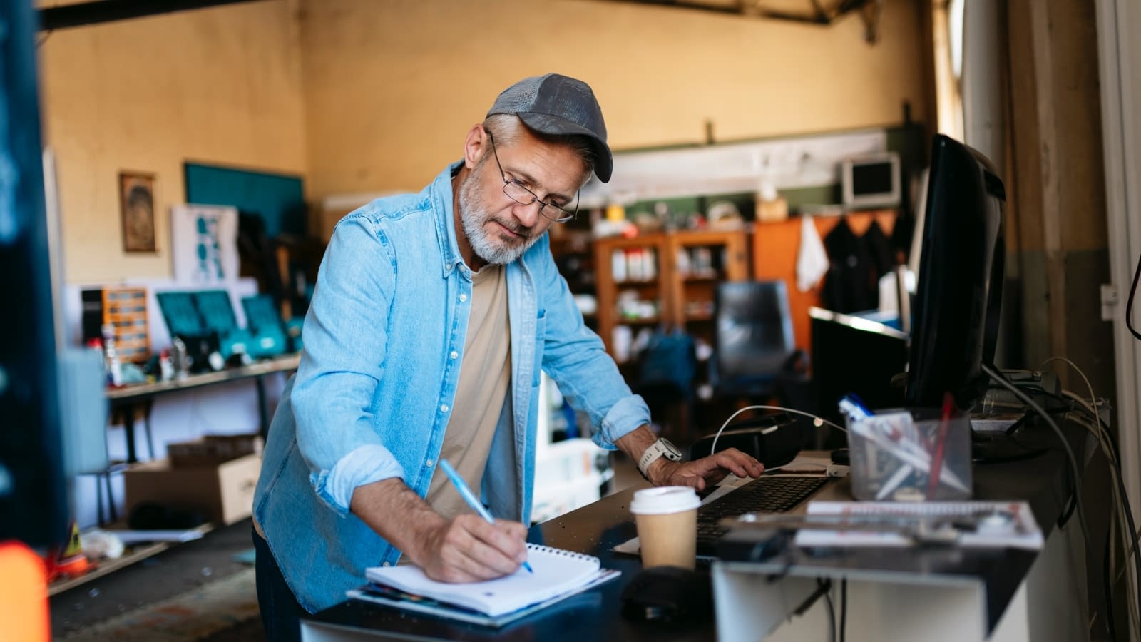 Older male business owner doing paperwork in his shop