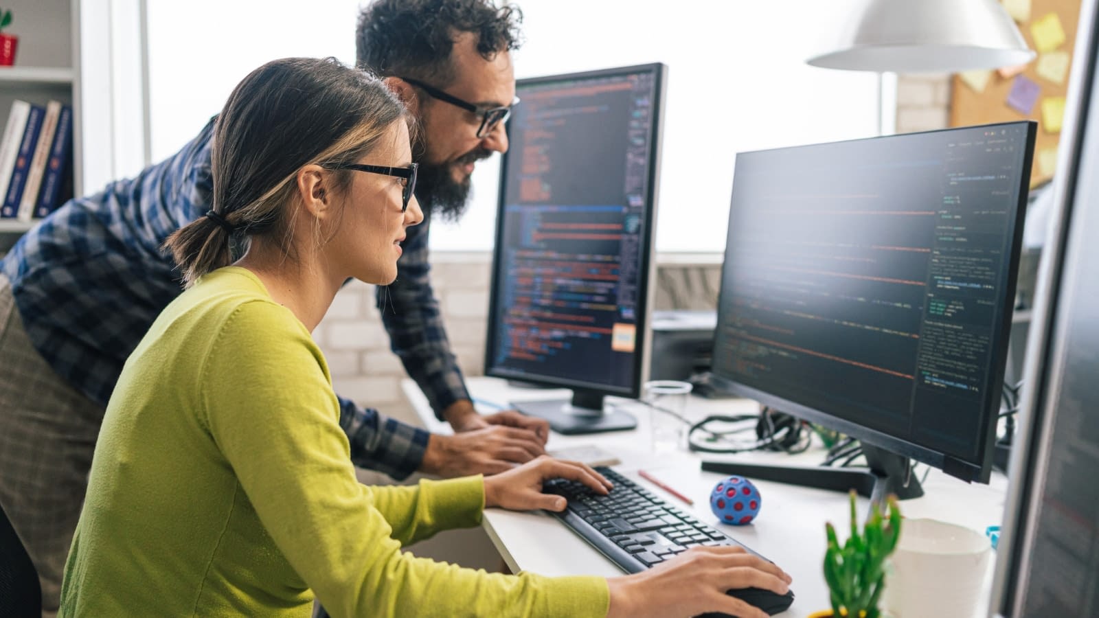 Female and male co-wokers looking at cyber security on computer