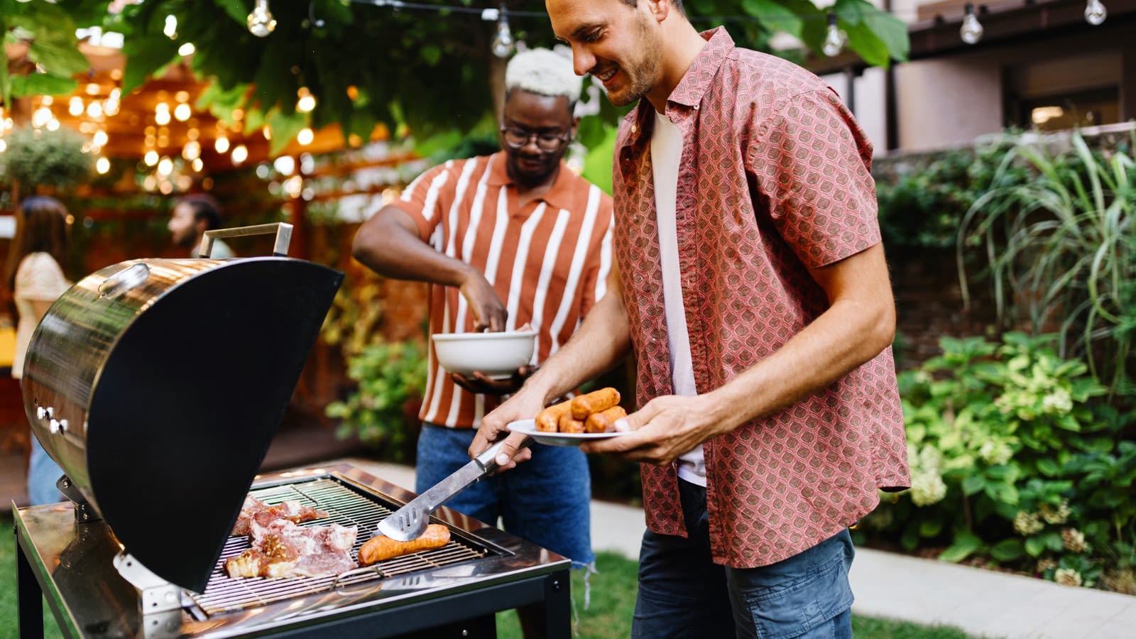 Two men grilling in backyard