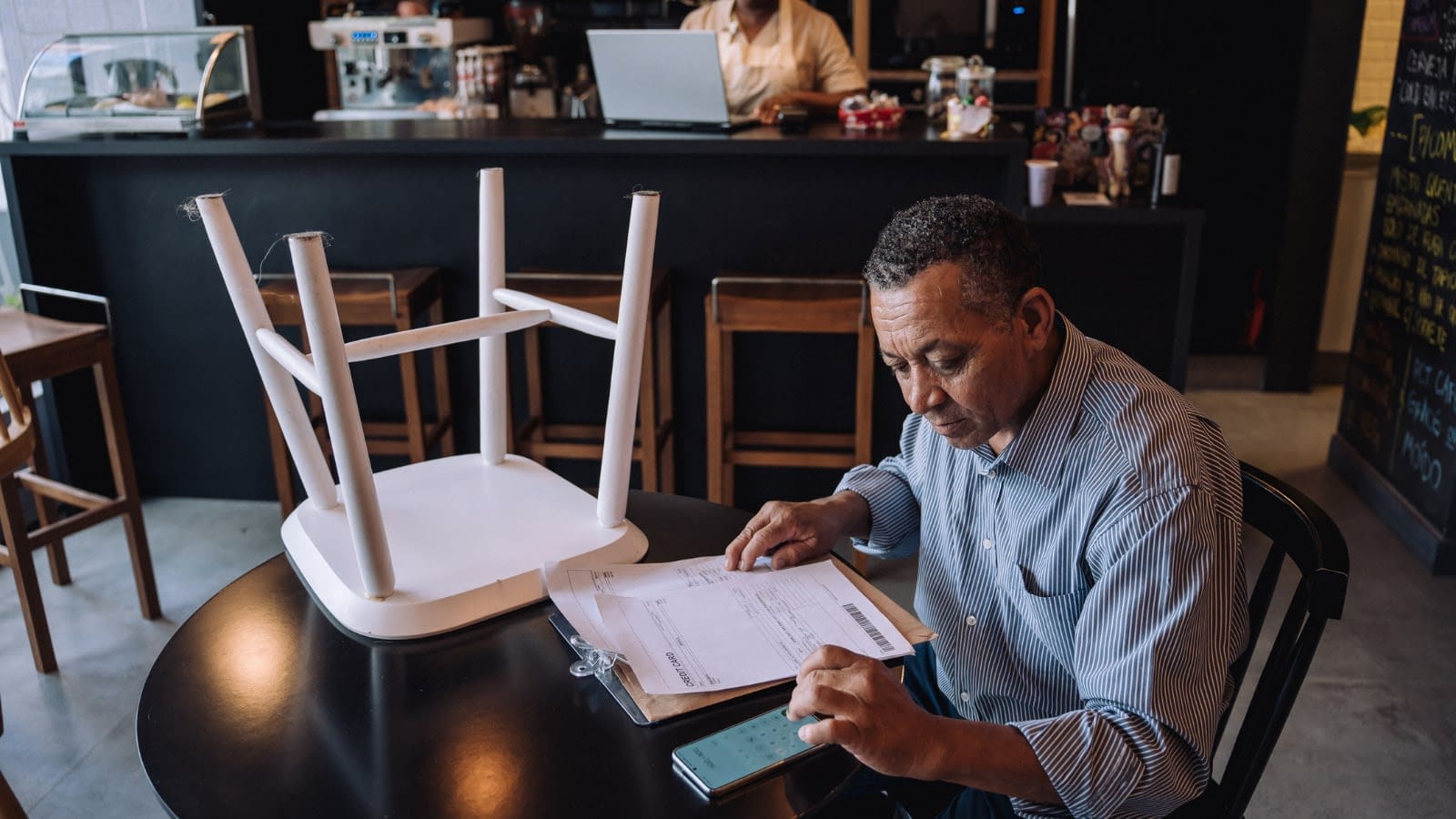 Restaurant owner sitting at table going over paperwork