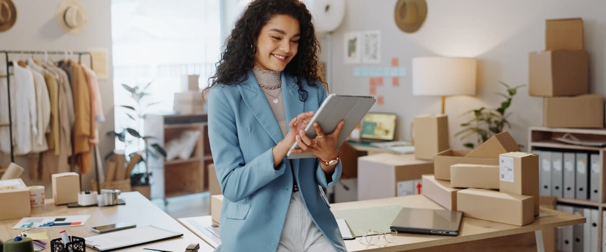 Young female business owner reading iPad.