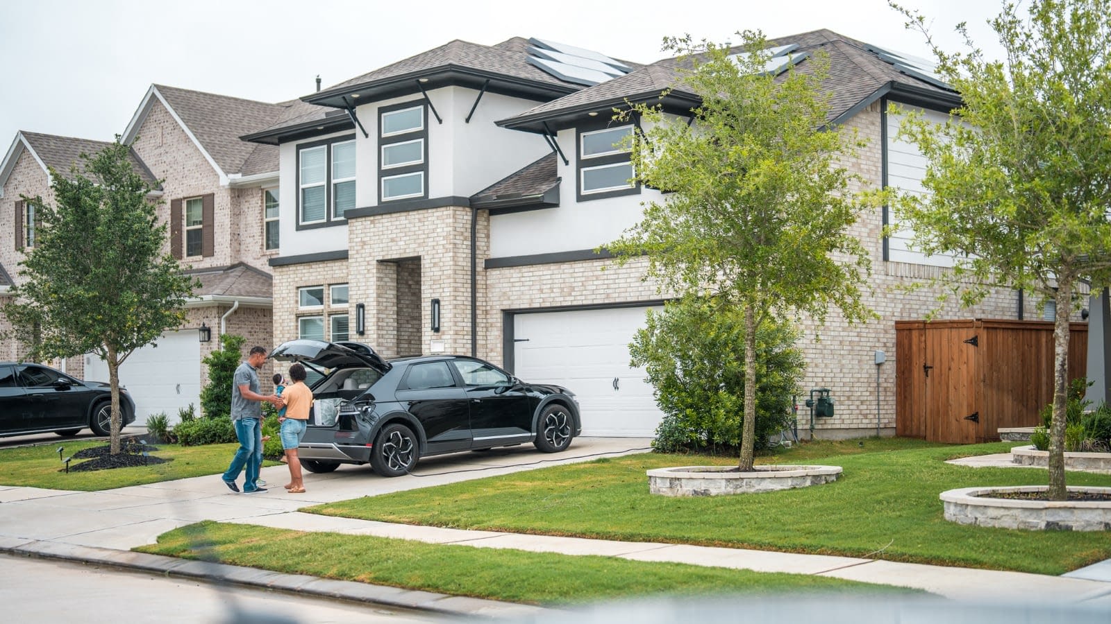 Family loading car in front of house