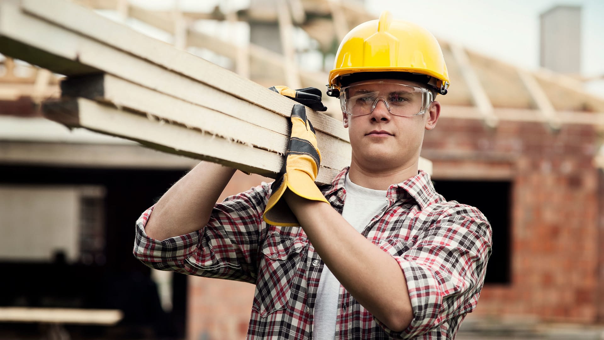 Construction worker carrying building materials